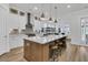 Bright, spacious kitchen featuring a large center island with seating, white cabinets and stainless steel appliances at 511 Ocean Mist Way, Summerville, SC 29486