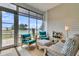 Cozy screened patio featuring comfortable chairs, an ottoman, and views of the backyard and lake at 511 Ocean Mist Way, Summerville, SC 29486