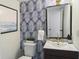 Updated powder room featuring striking wallpaper, modern fixtures, and a beautiful mirror at 519 Parkdale Dr # J, Charleston, SC 29414