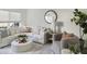 Bright living room with a large sofa, round mirror, plants, and plenty of natural light at 519 Parkdale Dr # J, Charleston, SC 29414