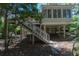 Elevated home with stairs showcases a unique architectural design surrounded by verdant trees and foliage at 554 Double Eagle Trce, Seabrook Island, SC 29455