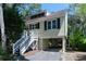 Beautiful beach house on stilts with black shutters, well-maintained landscaping, and a staircase to the front door at 554 Double Eagle Trce, Seabrook Island, SC 29455