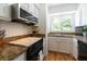 A kitchen with granite countertops, white cabinets, black appliances, and a window above the sink at 554 Double Eagle Trce, Seabrook Island, SC 29455