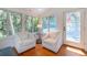 Cozy living room featuring hardwood floors, comfortable armchairs, and natural light from surrounding windows at 554 Double Eagle Trce, Seabrook Island, SC 29455