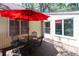 Outdoor patio with dining table and chairs under a vibrant red umbrella offering shade at 554 Double Eagle Trce, Seabrook Island, SC 29455