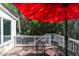 Outdoor patio featuring a table and chairs set under a red umbrella, overlooking lush greenery at 554 Double Eagle Trce, Seabrook Island, SC 29455