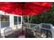 Outdoor patio with dining table under a red umbrella, ideal for enjoying meals outside with serene view at 554 Double Eagle Trce, Seabrook Island, SC 29455