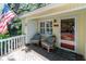 Inviting front porch with chairs, a table, and the American flag displayed, creating a welcoming atmosphere at 554 Double Eagle Trce, Seabrook Island, SC 29455