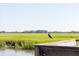 Captivating marsh view featuring a heron perched on a wooden railing, showcasing the serene natural beauty of the landscape at 555 Double Eagle, Seabrook Island, SC 29455