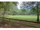 Expansive green pasture with a horse, surrounded by trees and wooden fences, offering a serene equestrian setting at 555 Double Eagle, Seabrook Island, SC 29455