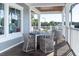 Inviting covered porch with outdoor dining furniture and neutral tones at 555 Double Eagle Trce, Seabrook Island, SC 29455