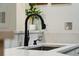 Close up of kitchen sink with black faucet, grey countertops, and plant in background at 60 Fenwick Hall Allee # 432, Johns Island, SC 29455
