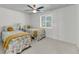 Bright bedroom featuring two twin beds, ceiling fan, and natural light from a window at 63 Mariners Cay, Folly Beach, SC 29439