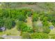 Aerial view showcases the expansive lot outlined in red, surrounded by lush greenery and mature trees at 7239 Commodore Rd, Hollywood, SC 29449