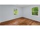 Inviting bedroom with hardwood floors and two bright windows overlooking the lush yard at 7239 Commodore Rd, Hollywood, SC 29449