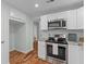Bright kitchen with stainless appliances, white cabinets, granite countertops and open floor plan at 7239 Commodore Rd, Hollywood, SC 29449