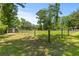 Expansive lawn with mature trees, enclosed by a secure fence for a serene and private setting at 7239 Commodore Rd, Hollywood, SC 29449