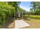 Outbuilding with concrete pad, situated in a fenced yard with mature trees at 7239 Commodore Rd, Hollywood, SC 29449