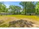 Residence with outbuilding situated on a large fenced lot dotted with mature trees at 7239 Commodore Rd, Hollywood, SC 29449