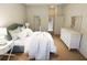Well-lit bedroom includes wood floors, a dresser, and convenient access to a bathroom at 7423 Indigo Palms Way, Johns Island, SC 29455