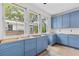 Bright kitchen with blue cabinetry, three large windows, and hardwood floors getting ready for countertops at 931 Kincade Dr, Mount Pleasant, SC 29464