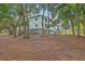 View of three-story building featuring balconies surrounded by mature trees and foliage at 1025 Riverland Woods Pl # 904, Charleston, SC 29412