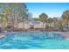 Inviting community pool with an adjacent clubhouse surrounded by lush landscaping at 1025 Riverland Woods Pl # 904, Charleston, SC 29412