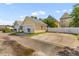 View of garages and driveways of yellow and blue homes, separated by a white fence at 104 Hyacinth St, Summerville, SC 29483