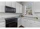 Modern kitchen featuring white cabinets, granite countertops, and black appliances at 104 Hyacinth St, Summerville, SC 29483