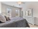 Bright main bedroom features a grey comforter, white dresser and two windows providing plenty of natural light at 104 Hyacinth St, Summerville, SC 29483