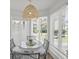 Sunlit breakfast nook with a glass table and seating for four near shuttered windows at 9000 Palmetto Dr # C104, Isle of Palms, SC 29451