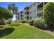 Charming exterior of a multi-story home with balconies, lush landscaping, and a well-maintained lawn at 9000 Palmetto Dr # C104, Isle of Palms, SC 29451
