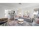 Open-concept living room with view to modern kitchen and breakfast bar seating at 9000 Palmetto Dr # C104, Isle of Palms, SC 29451