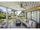 Relaxing screened-in porch featuring comfortable seating, overhead fan and partial ocean views at 9000 Palmetto Dr # C104, Isle of Palms, SC 29451