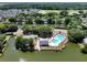 Aerial view of a community pool, tennis court, and nearby lake surrounded by homes in a lush, green neighborhood at 1048 Wayfarer Ln, Charleston, SC 29412