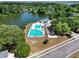 Aerial view of community pool, clubhouse, and surrounding landscape with trees and water in a serene neighborhood at 1048 Wayfarer Ln, Charleston, SC 29412