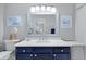 Bathroom with navy vanity, white countertop and basin sink, decorated with nautical themed art and silver trimmed mirror at 1048 Wayfarer Ln, Charleston, SC 29412