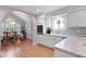 Well-lit kitchen with white cabinets, neutral countertops, and an arched entryway to dining at 1048 Wayfarer Ln, Charleston, SC 29412