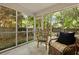Cozy screened-in porch with wicker seating, views of the backyard and garden with idyllic relaxation and tranquility at 1048 Wayfarer Ln, Charleston, SC 29412