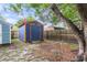 Backyard shed with orange trim and blue paint and a surrounding wooden fence at 1060 Oakcrest Dr, Charleston, SC 29412