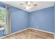 Blue bedroom features wood-look floors, a ceiling fan, and a window with curtains at 1060 Oakcrest Dr, Charleston, SC 29412