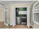 Laundry room closet with stainless steel washer and dryer and white cabinets, and a glass door at 1060 Oakcrest Dr, Charleston, SC 29412