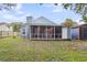Backyard view of the house, which features a screened-in patio and wooden shed at 1060 Oakcrest Dr, Charleston, SC 29412