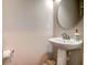 Elegant powder room featuring a pedestal sink, modern faucet, and round mirror at 1061 Ashley Gardens Blvd, Charleston, SC 29414
