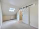 Bedroom with skylight, sliding barn door, and neutral decor creating a serene space at 1115 Shadow Lake Cir, Mount Pleasant, SC 29464