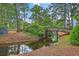 Scenic view of a community with a charming bridge over a creek surrounded by lush greenery and mature trees at 1115 Shadow Lake Cir, Mount Pleasant, SC 29464