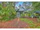 Charming home exterior with a screened-in porch and a landscaped yard surrounded by lush greenery and mature trees at 1115 Shadow Lake Cir, Mount Pleasant, SC 29464