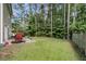 Spacious backyard featuring a patio, grill, green lawn, and a wooded area for outdoor enjoyment at 113 Southernwood Dr, Ladson, SC 29456