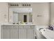Bathroom featuring a double vanity, soaking tub, and a large mirror, designed for comfort and convenience at 113 Southernwood Dr, Ladson, SC 29456