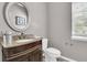 Elegant half-bathroom with granite vanity, a round mirror and tiled floor next to a white toilet at 113 Southernwood Dr, Ladson, SC 29456